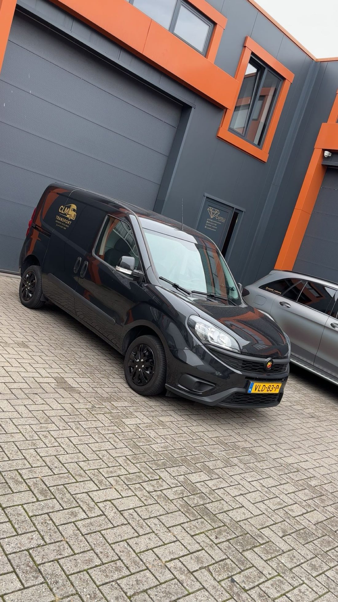 Vooraanzicht van de zwarte CLM Transport bestelbus